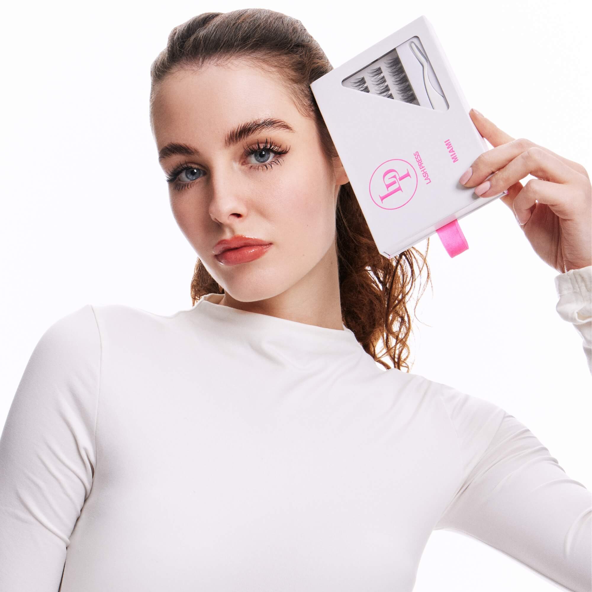 Woman wearing and holding lash press press on wispey lashes