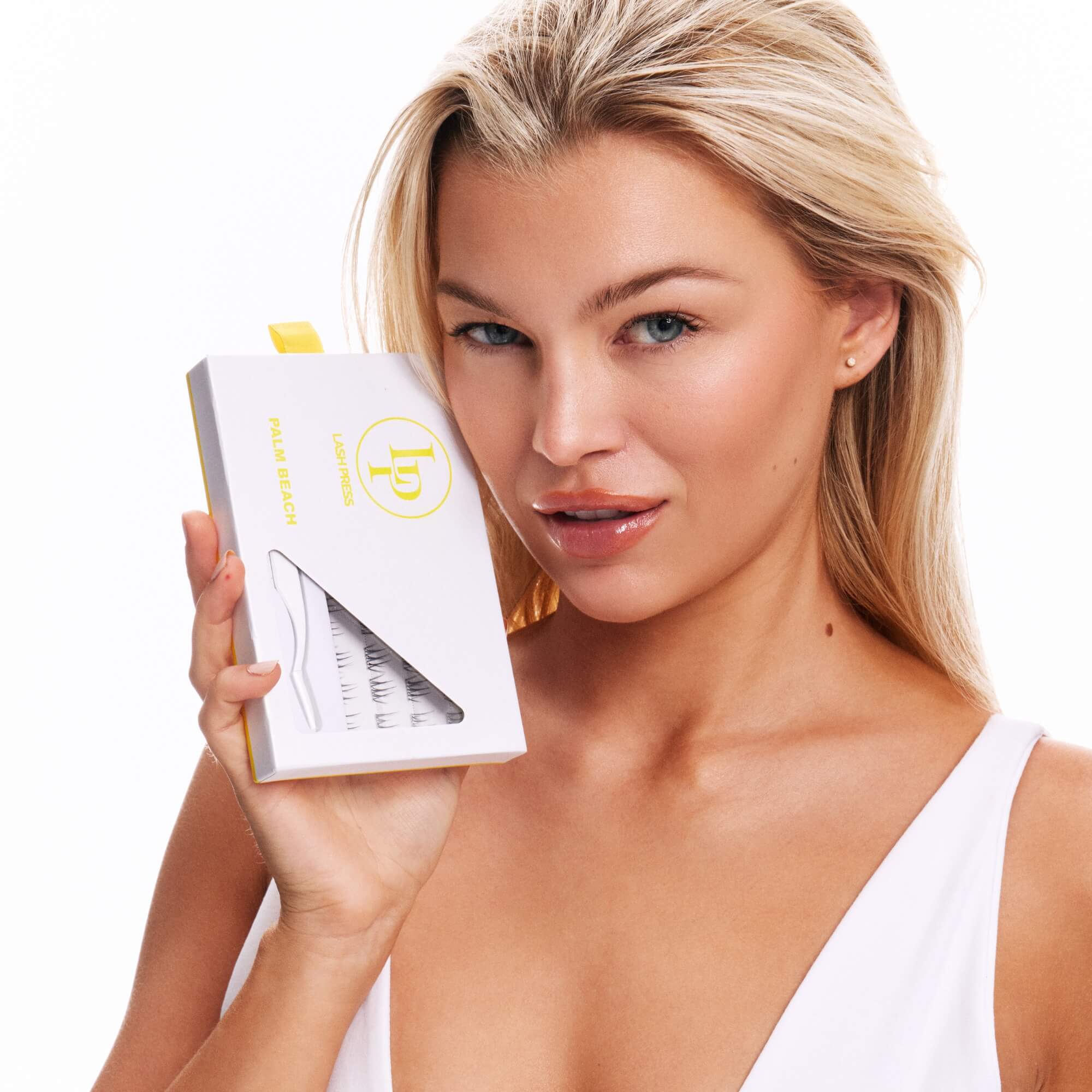 Woman wearing lash press press-on super natural lashes holding box